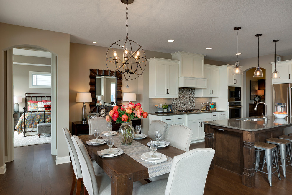 Inspiration for a transitional dark wood floor kitchen remodel in Minneapolis with a double-bowl sink, white cabinets, quartzite countertops, multicolored backsplash, mosaic tile backsplash, stainless steel appliances and an island