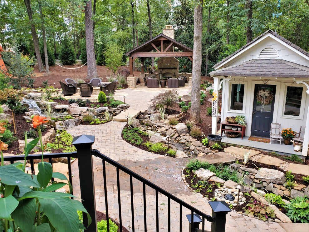 Design ideas for a large country backyard garden in Atlanta with with waterfall and concrete pavers.