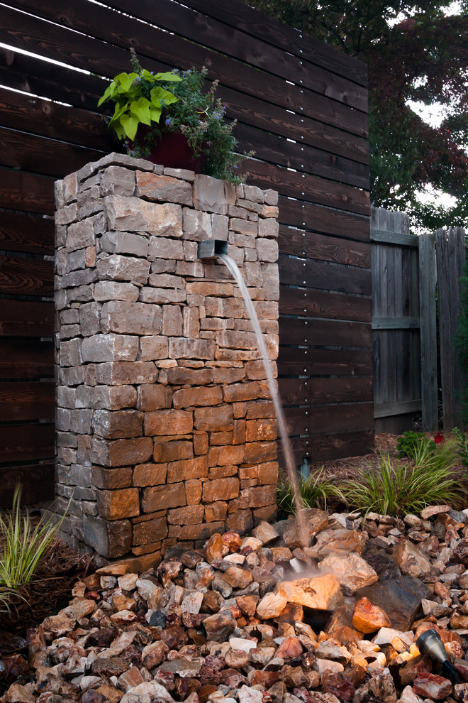 Photo of a mid-sized traditional backyard garden in Oklahoma City with a water feature and natural stone pavers.