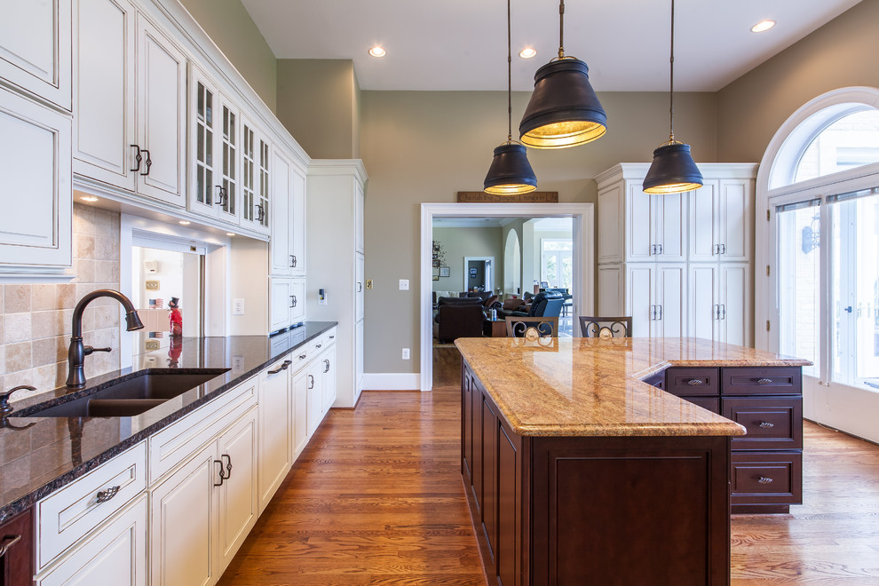 Eat-in kitchen - huge transitional medium tone wood floor eat-in kitchen idea in DC Metro with raised-panel cabinets, granite countertops, stainless steel appliances and an island