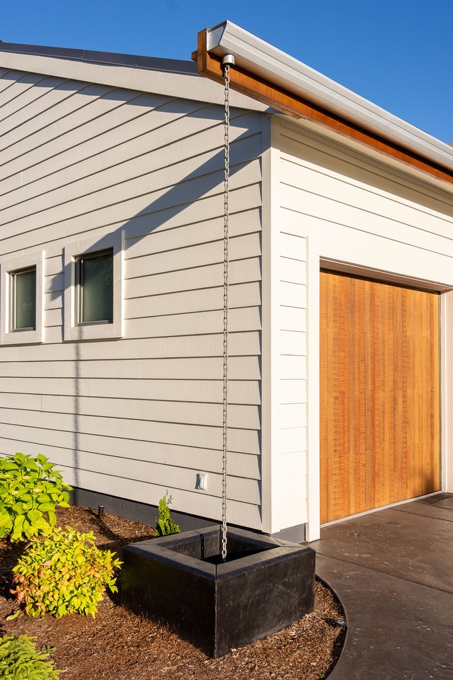 Example of a huge 1960s white two-story wood and clapboard gable roof design in Portland with a metal roof and a gray roof