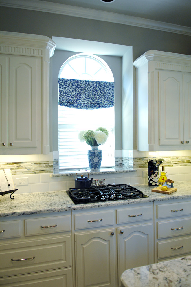 Inspiration for a large transitional u-shaped eat-in kitchen remodel in Dallas with white cabinets, granite countertops, multicolored backsplash, matchstick tile backsplash, stainless steel appliances and an island