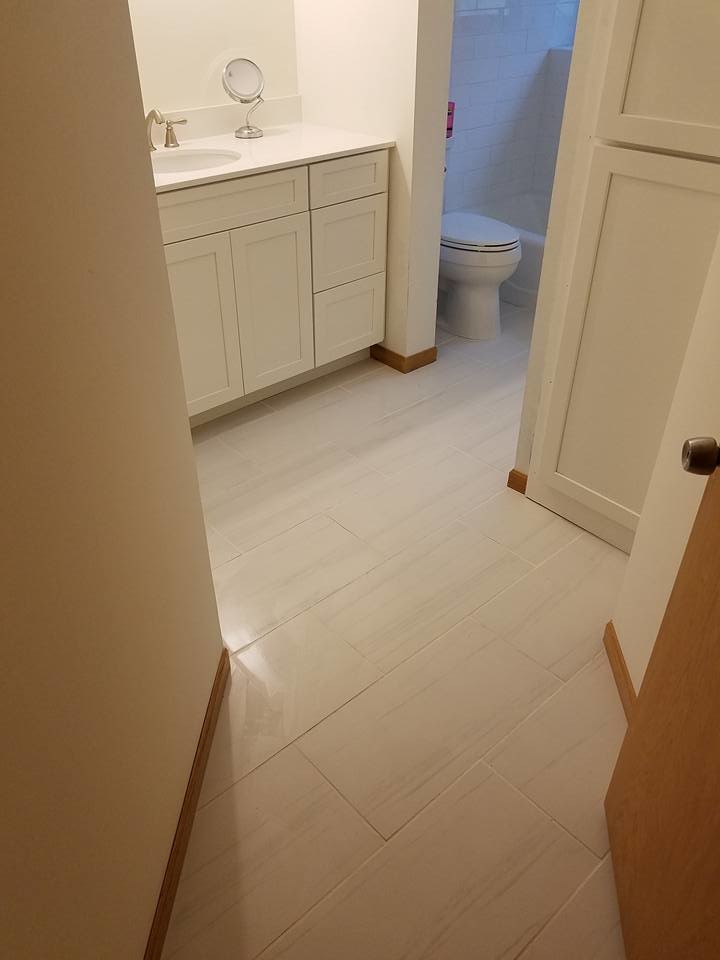 Alcove bathtub - mid-sized transitional 3/4 white tile and subway tile laminate floor and beige floor alcove bathtub idea with shaker cabinets, white cabinets, a two-piece toilet, beige walls, an undermount sink, solid surface countertops and white countertops