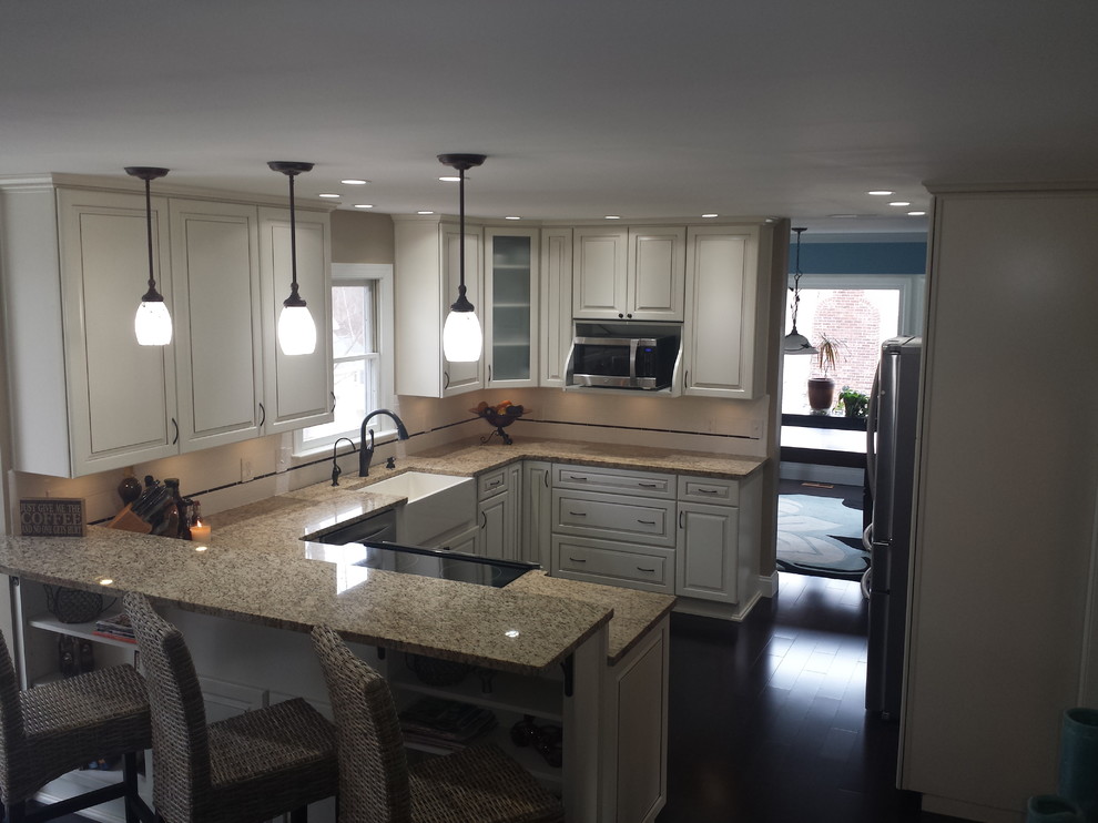 Inspiration for a large transitional u-shaped dark wood floor eat-in kitchen remodel in DC Metro with a farmhouse sink, raised-panel cabinets, white cabinets, granite countertops, white backsplash, subway tile backsplash and stainless steel appliances