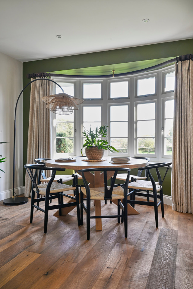 Ispirazione per una sala da pranzo aperta verso la cucina nordica di medie dimensioni con pareti verdi, pavimento in legno massello medio e pavimento marrone