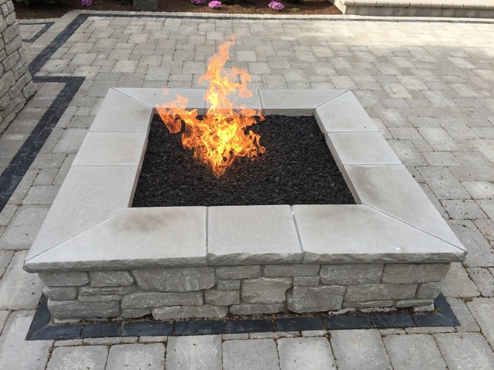 Photo of a large traditional backyard patio in Chicago with a fire feature, natural stone pavers and no cover.