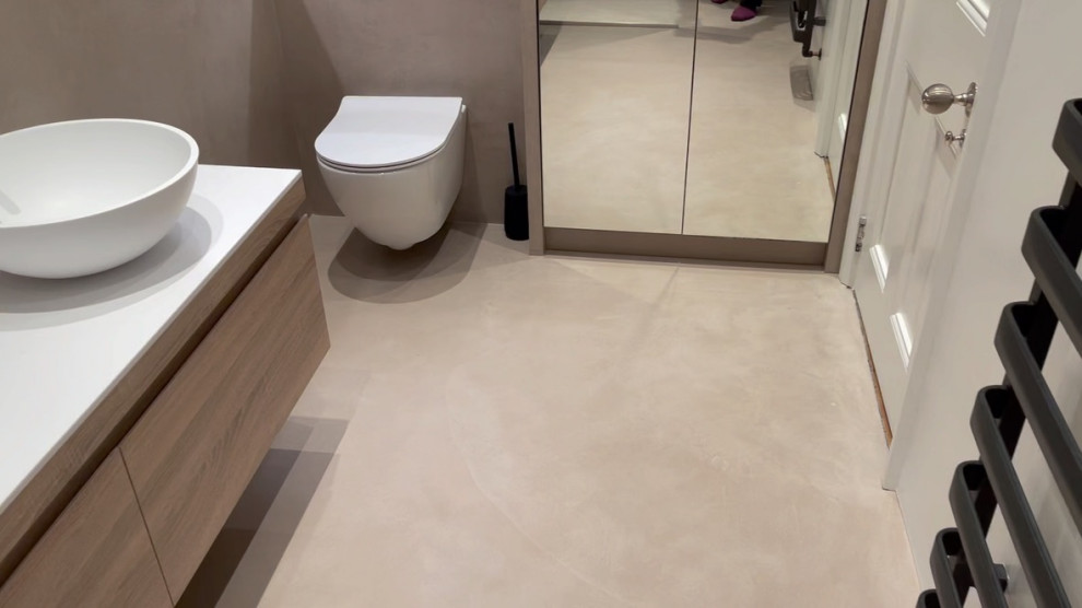 Inspiration for a medium sized modern bathroom in London with flat-panel cabinets, medium wood cabinets, a wall mounted toilet, brown walls, concrete flooring, engineered stone worktops, brown floors, an open shower, white worktops, a wall niche, double sinks, a floating vanity unit and a vessel sink.