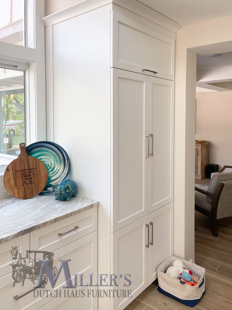 Photo of a large classic u-shaped kitchen/diner in Tampa with shaker cabinets, multiple islands and beige floors.