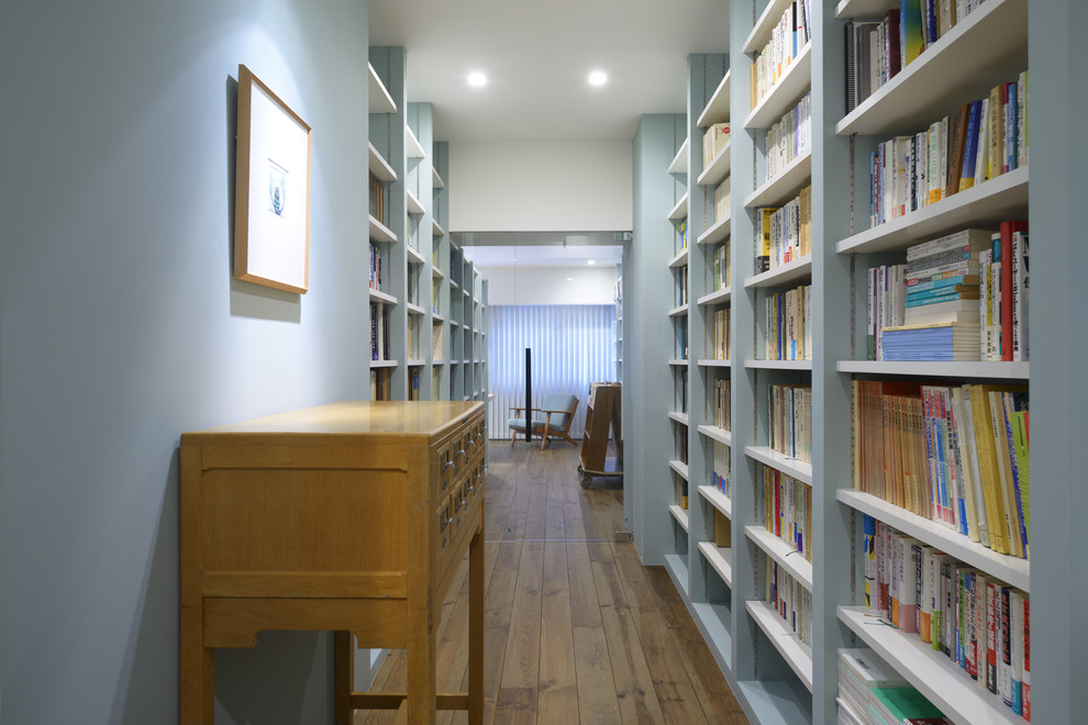 他の地域にある広いおしゃれな書斎 (青い壁、無垢フローリング、暖炉なし、自立型机) の写真