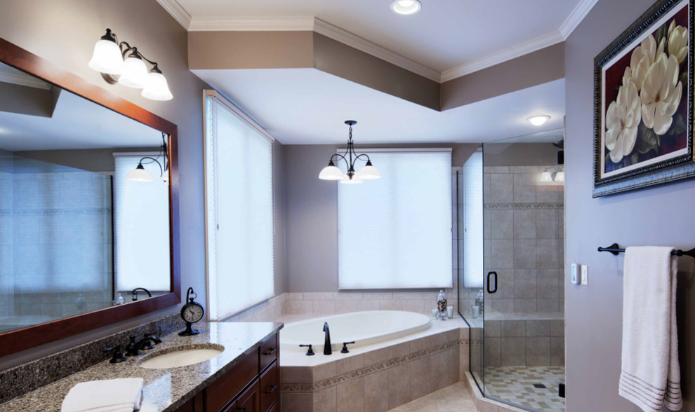 Inspiration for a large transitional master black tile drop-in bathtub remodel with raised-panel cabinets, dark wood cabinets, an undermount sink and a hinged shower door