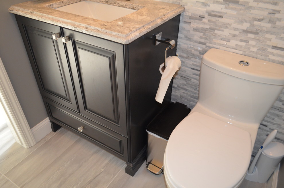 This is an example of a small transitional 3/4 bathroom in New York with raised-panel cabinets, grey cabinets, gray tile, pebble tile, grey walls and engineered quartz benchtops.