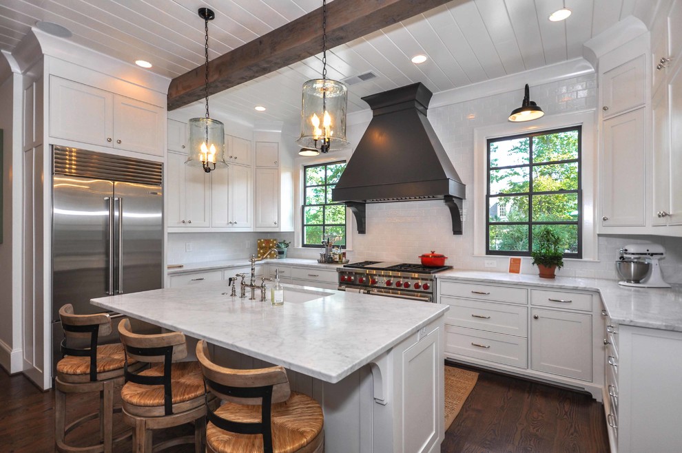 Photo of a traditional u-shaped kitchen in Atlanta with an undermount sink, beaded inset cabinets, white cabinets, white splashback, stainless steel appliances, dark hardwood floors and with island.