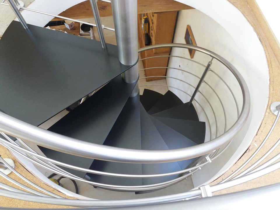 Photo of a mid-sized contemporary metal spiral staircase in Paris with open risers and metal railing.