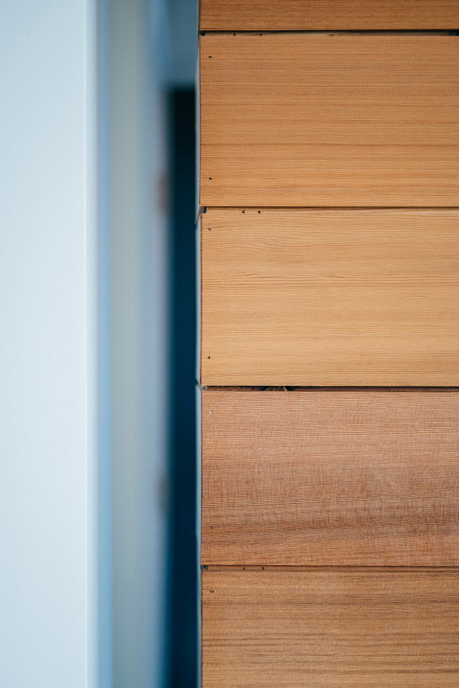 Immagine di un piccolo corridoio minimalista con una porta singola e pareti in legno