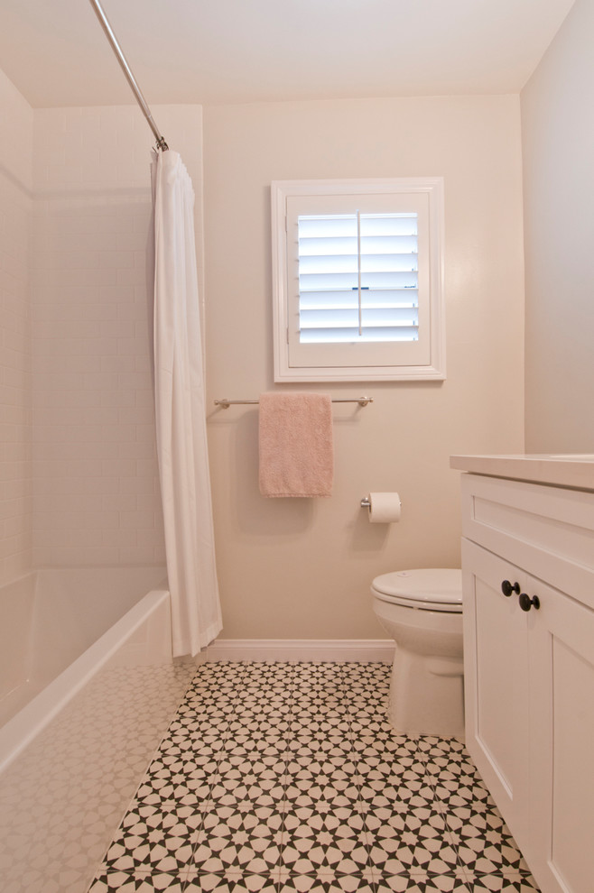 Design ideas for a small transitional kids bathroom in Los Angeles with shaker cabinets, white cabinets, a drop-in tub, a shower/bathtub combo, a two-piece toilet, white tile, ceramic tile, beige walls, terra-cotta floors, an undermount sink, engineered quartz benchtops, multi-coloured floor, a shower curtain and white benchtops.