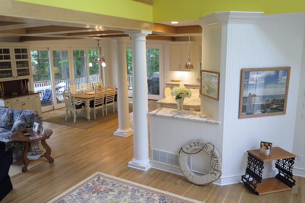 Inspiration for a mid-sized coastal l-shaped light wood floor eat-in kitchen remodel with an undermount sink, shaker cabinets, white cabinets, marble countertops, white backsplash, stone tile backsplash, stainless steel appliances and an island