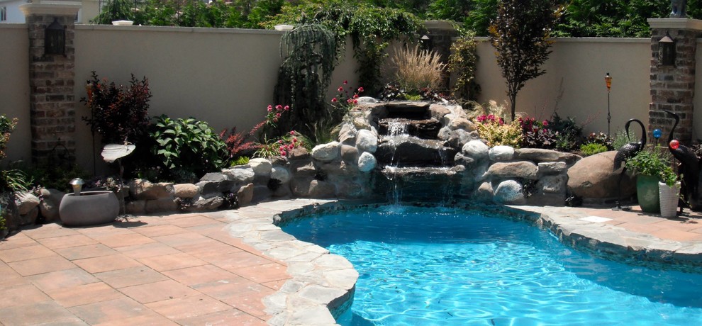 Design ideas for a large traditional backyard garden in New York with concrete pavers.