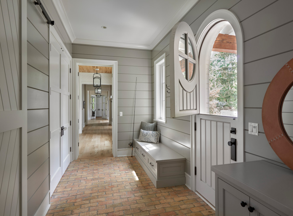 Inspiration for a brick floor and shiplap wall entryway remodel in Chicago with gray walls and a white front door
