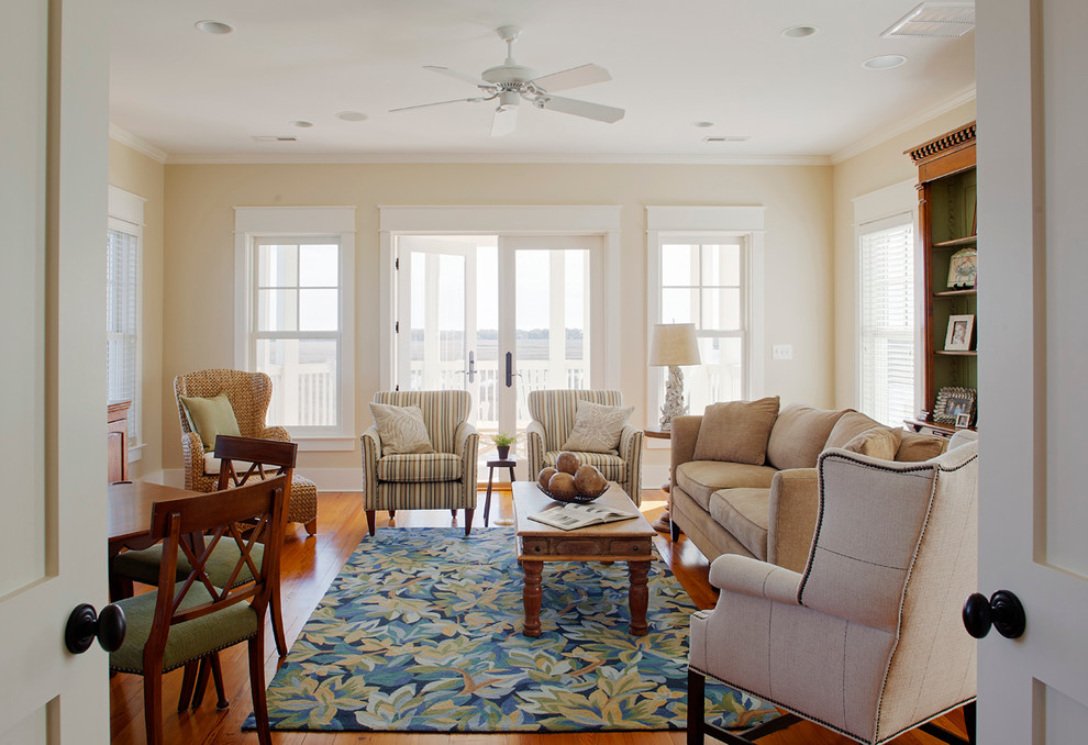 Design ideas for a large beach style enclosed living room in Charleston with a library, beige walls, medium hardwood floors and a freestanding tv.