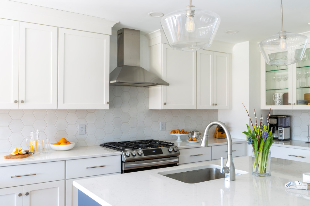 Bild på ett mellanstort vintage vit vitt kök, med en undermonterad diskho, skåp i shakerstil, vita skåp, bänkskiva i kvarts, grått stänkskydd, stänkskydd i porslinskakel, rostfria vitvaror, mellanmörkt trägolv och en köksö