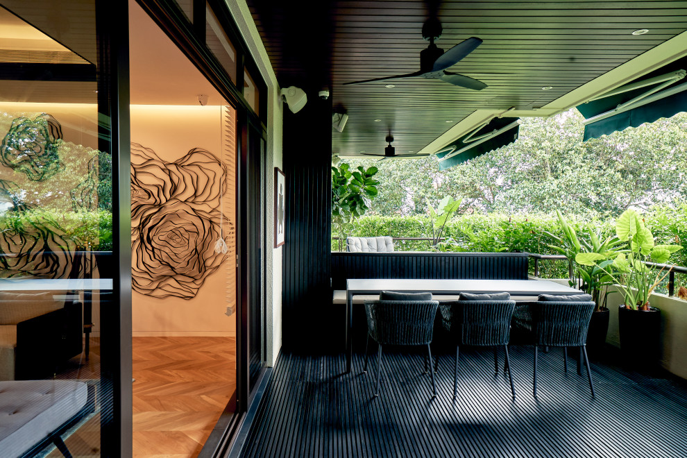 Photo of a small contemporary balcony in Singapore with with privacy feature, a roof extension and mixed railing.