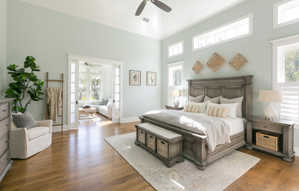 Cette photo montre une chambre parentale chic avec un mur gris, un sol en bois brun, aucune cheminée, un sol marron, un plafond en lambris de bois et un plafond voûté.