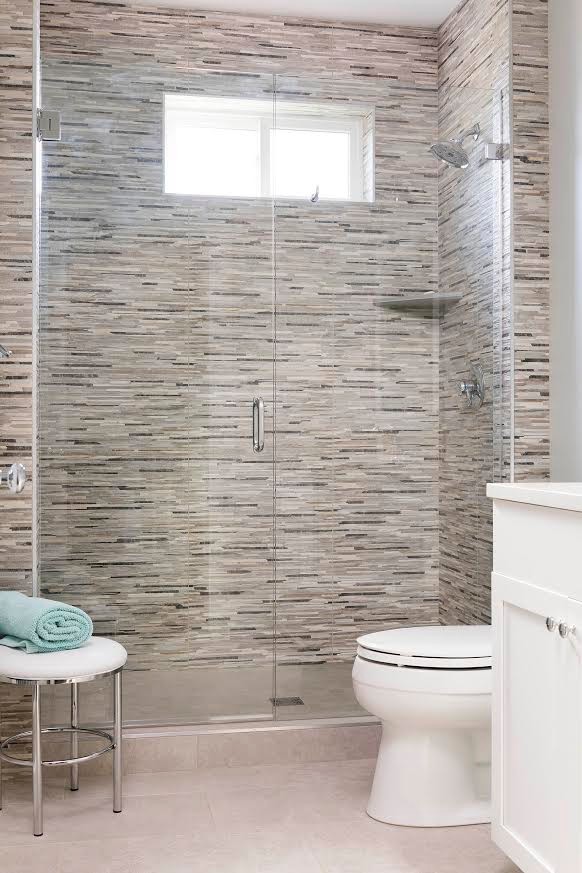 Photo of a mid-sized country 3/4 bathroom in Seattle with shaker cabinets, white cabinets, an alcove shower, a two-piece toilet, gray tile, matchstick tile, grey walls, porcelain floors, solid surface benchtops, grey floor and a hinged shower door.