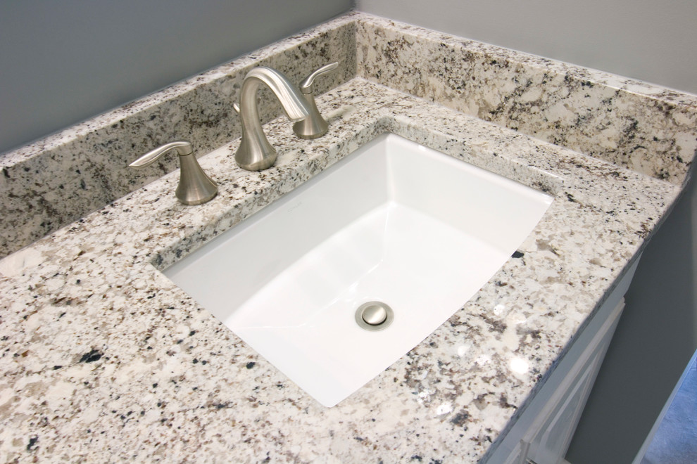 Walk-in shower - mid-sized transitional master gray tile and ceramic tile ceramic tile walk-in shower idea with an undermount sink, raised-panel cabinets, white cabinets, granite countertops, a two-piece toilet and gray walls