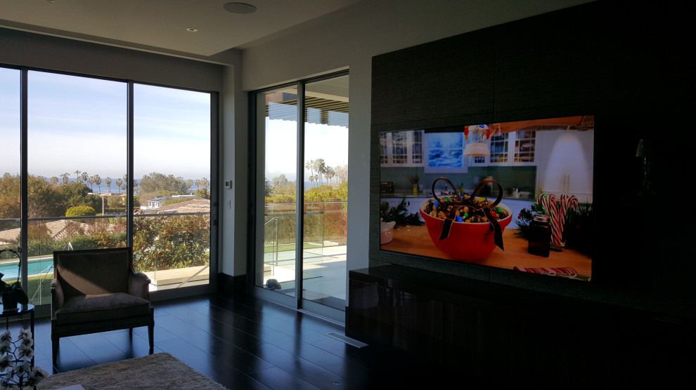Exemple d'une grande salle de séjour moderne ouverte avec un mur marron, parquet foncé, un sol marron et du lambris.