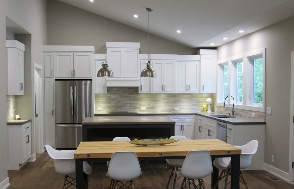 Open concept kitchen - large transitional l-shaped dark wood floor open concept kitchen idea in Grand Rapids with an undermount sink, shaker cabinets, white cabinets, quartz countertops, beige backsplash, porcelain backsplash, stainless steel appliances and an island