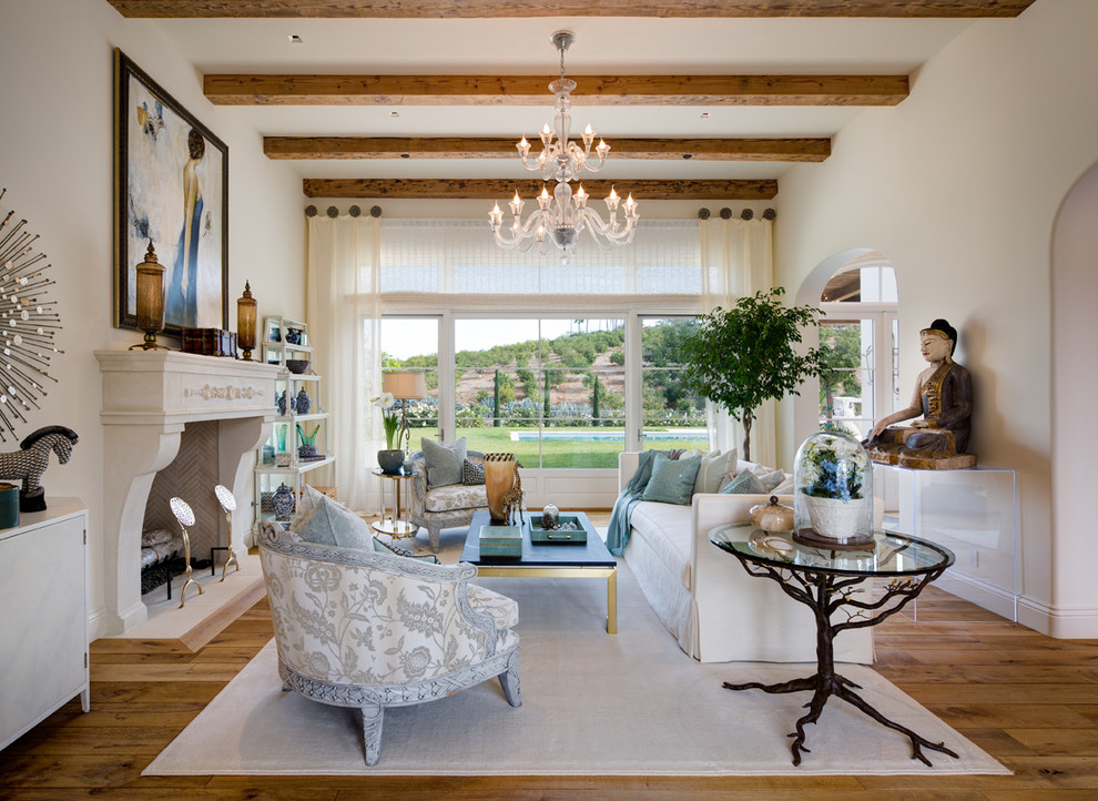 Example of a tuscan formal and enclosed light wood floor living room design in San Diego with white walls and a standard fireplace