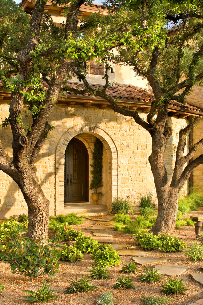 This is an example of a mediterranean partial sun garden in Austin with a garden path and natural stone pavers.
