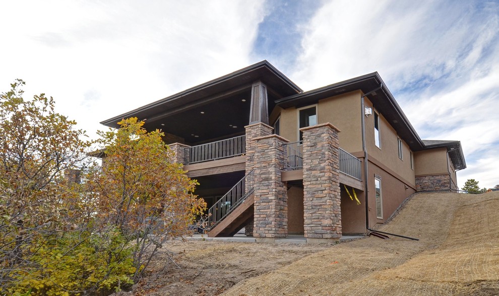 Design ideas for a modern one-storey beige exterior in Denver with stone veneer.