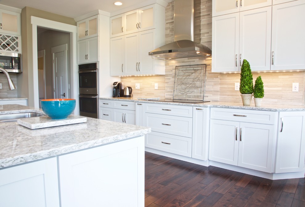 Inspiration for a mid-sized transitional galley eat-in kitchen remodel with white cabinets, granite countertops, beige backsplash, stone tile backsplash and stainless steel appliances