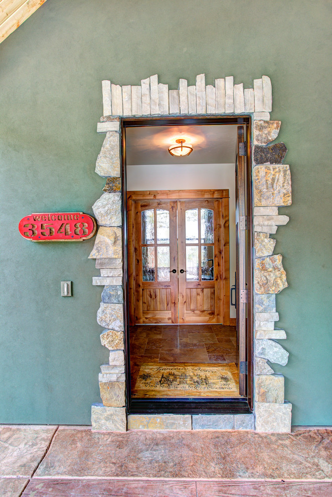 Front door - large rustic front door idea with green walls and a dark wood front door
