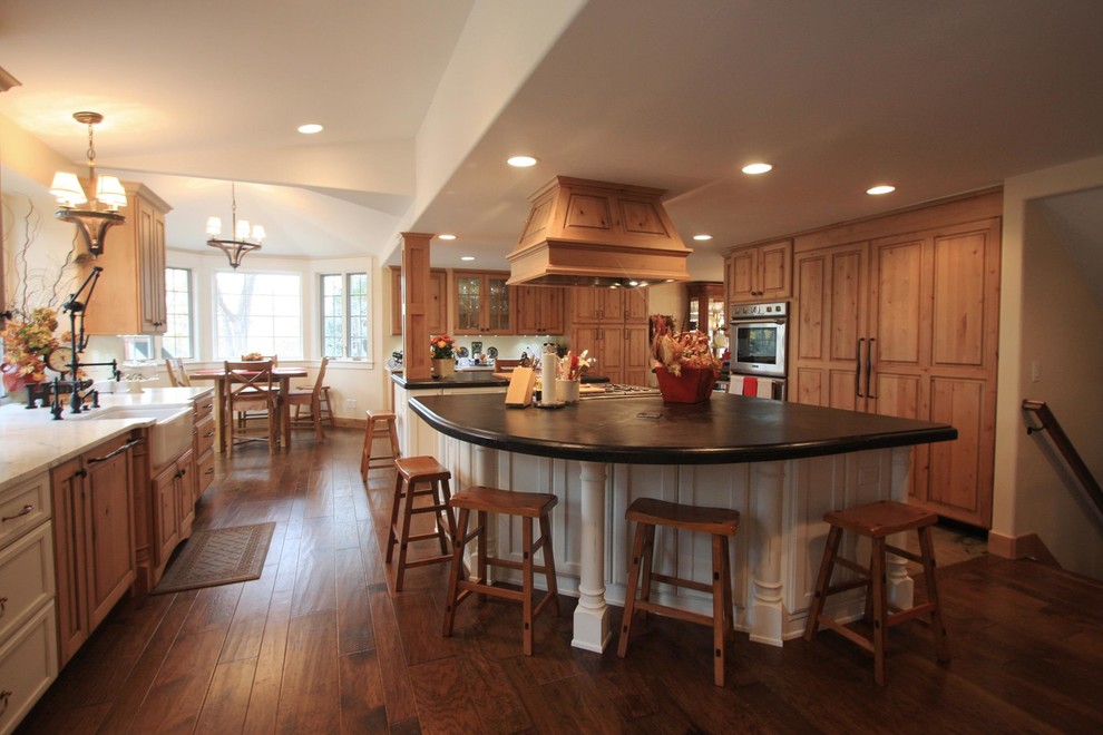 Inspiration for a huge transitional medium tone wood floor and brown floor eat-in kitchen remodel in Denver with a farmhouse sink, raised-panel cabinets, distressed cabinets, two islands, stainless steel appliances and granite countertops