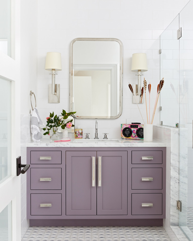 Идея дизайна: ванная комната в стиле неоклассика (современная классика) с фасадами в стиле шейкер, фиолетовыми фасадами, душем в нише, белой плиткой, белыми стенами, врезной раковиной, серым полом, белой столешницей, тумбой под одну раковину и встроенной тумбой