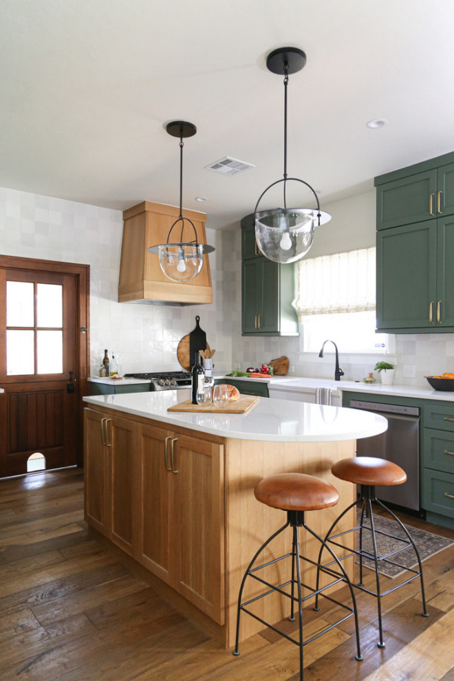 Bild på ett litet vintage vit vitt kök, med en rustik diskho, skåp i shakerstil, gröna skåp, bänkskiva i kvarts, vitt stänkskydd, stänkskydd i porslinskakel, rostfria vitvaror, mellanmörkt trägolv, en köksö och brunt golv