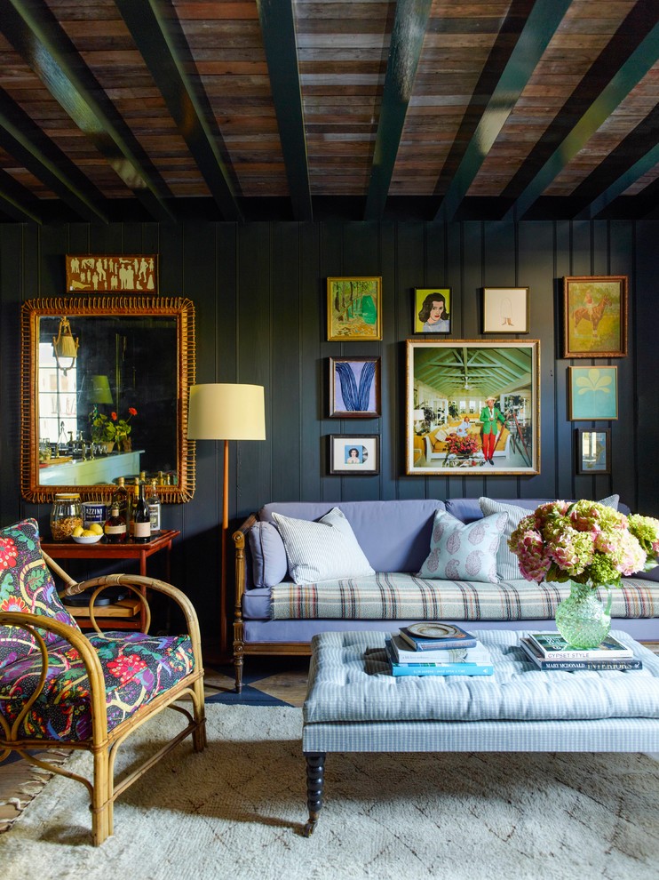 На фото: гостиная комната в викторианском стиле с синими стенами, балками на потолке, панелями на части стены и синим диваном