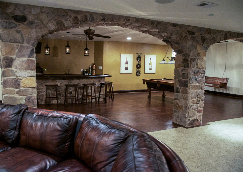 Large traditional look-out basement in Philadelphia with beige walls, dark hardwood floors and multi-coloured floor.