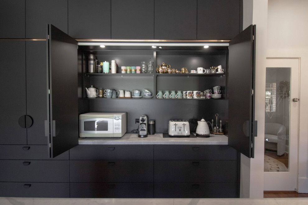 Idéer för stora funkis vitt kök, med en undermonterad diskho, luckor med infälld panel, svarta skåp, bänkskiva i kvarts, stänkskydd med metallisk yta, svarta vitvaror, mellanmörkt trägolv och en köksö
