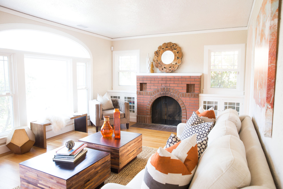 This is an example of a transitional family room in Sacramento with beige walls, medium hardwood floors, a standard fireplace and a brick fireplace surround.