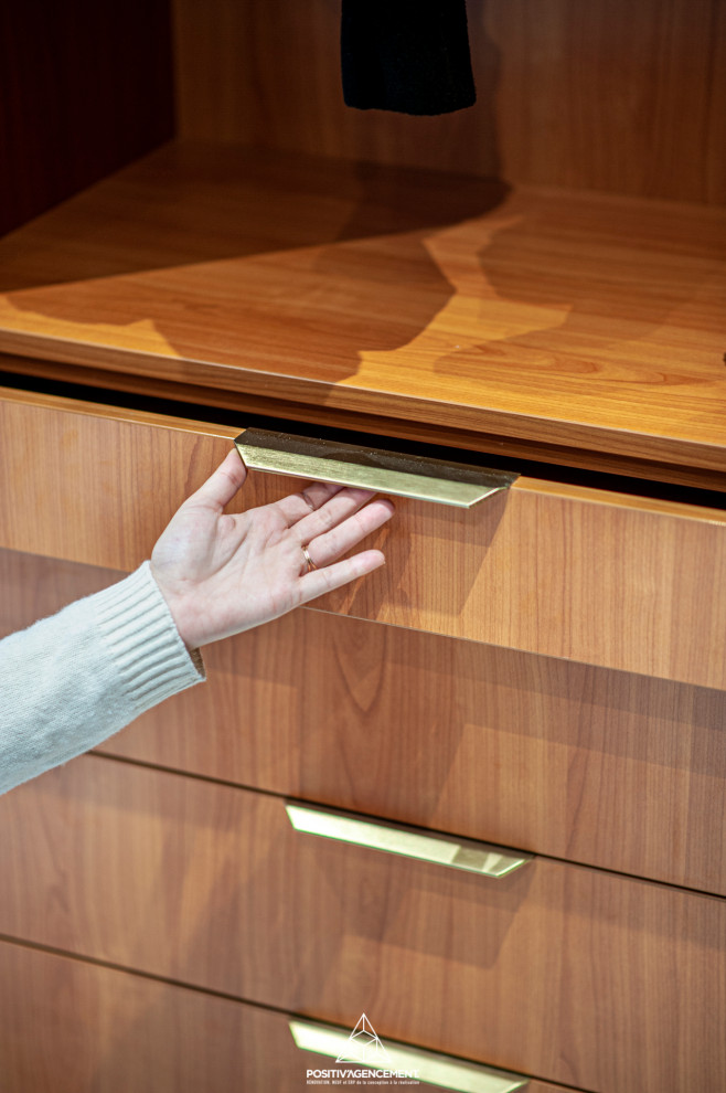 This is an example of a large modern gender-neutral dressing room in Other with open cabinets, medium wood cabinets, ceramic floors, white floor and coffered.