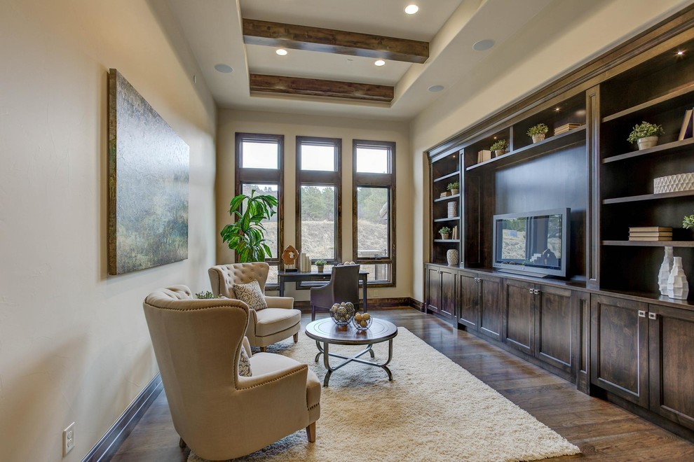 Photo of a mid-sized mediterranean enclosed family room in Denver with beige walls, medium hardwood floors, no fireplace, a built-in media wall and brown floor.