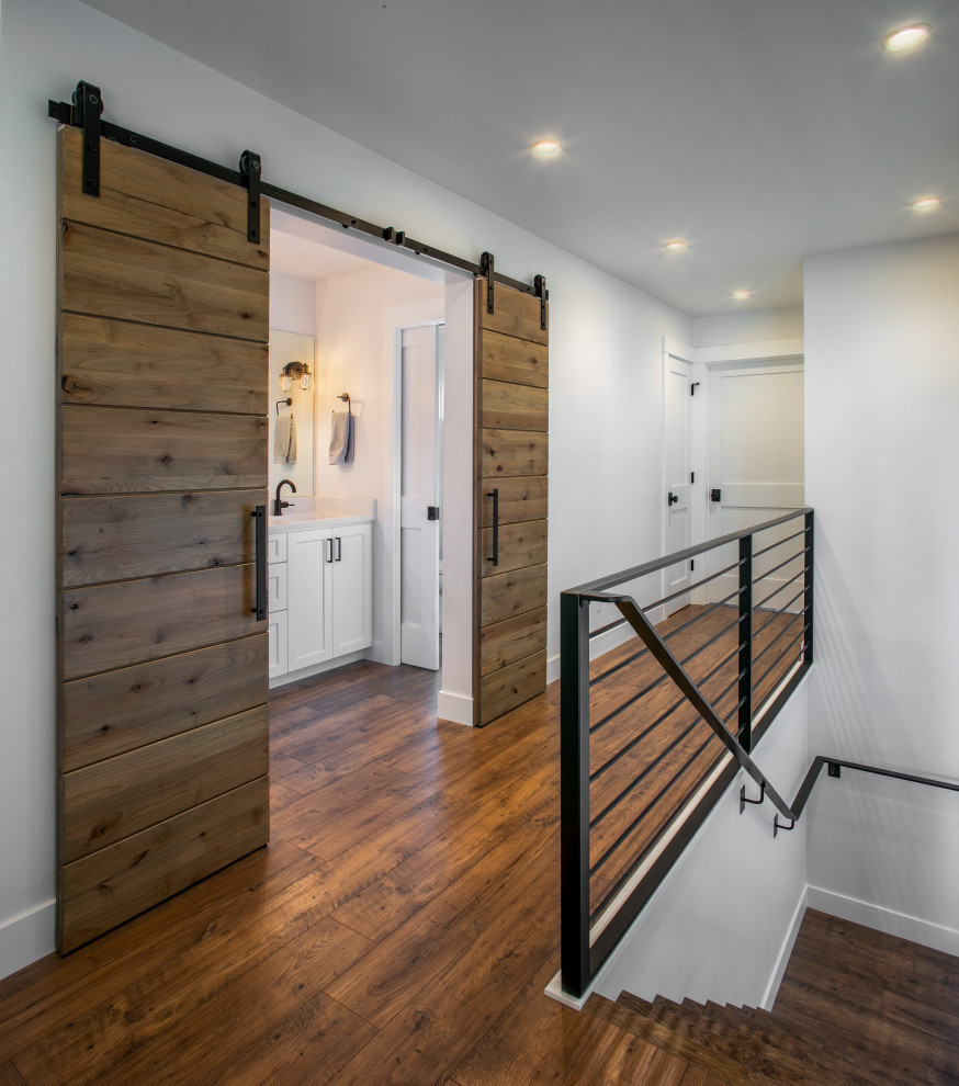 Design ideas for a mid-sized hallway in Seattle with white walls, laminate floors and brown floor.