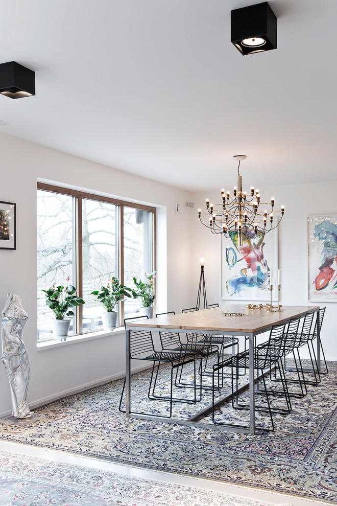 This is an example of a mid-sized scandinavian dining room in Stockholm with white walls and no fireplace.