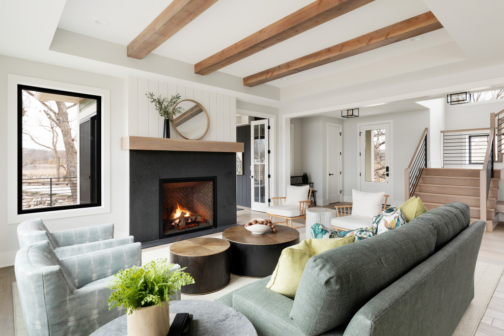Transitional formal open concept living room in Minneapolis with white walls, light hardwood floors, a standard fireplace, a brick fireplace surround, no tv, beige floor and exposed beam.