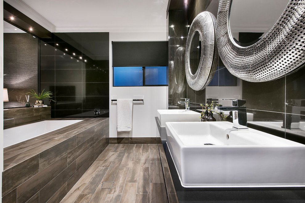 Contemporary master bathroom in Perth with flat-panel cabinets, black cabinets, a drop-in tub, black tile, black walls, a vessel sink, brown floor and black benchtops.