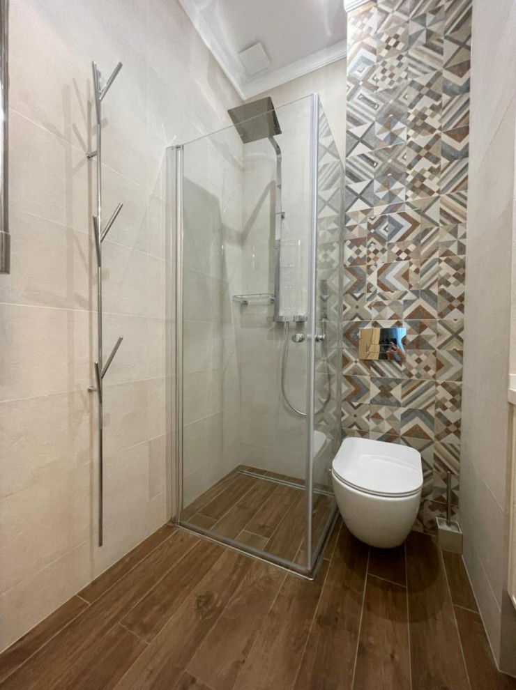 Small scandi shower room bathroom in Moscow with raised-panel cabinets, beige cabinets, a built-in shower, a wall mounted toilet, beige tiles, ceramic tiles, beige walls, ceramic flooring, an integrated sink, solid surface worktops, brown floors, a hinged door, beige worktops, a single sink and a floating vanity unit.