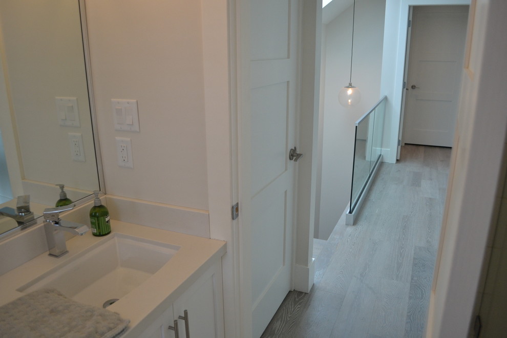 Small contemporary 3/4 bathroom in Vancouver with an undermount sink, shaker cabinets, white cabinets, engineered quartz benchtops, a drop-in tub, a shower/bathtub combo, a two-piece toilet, white walls and ceramic floors.